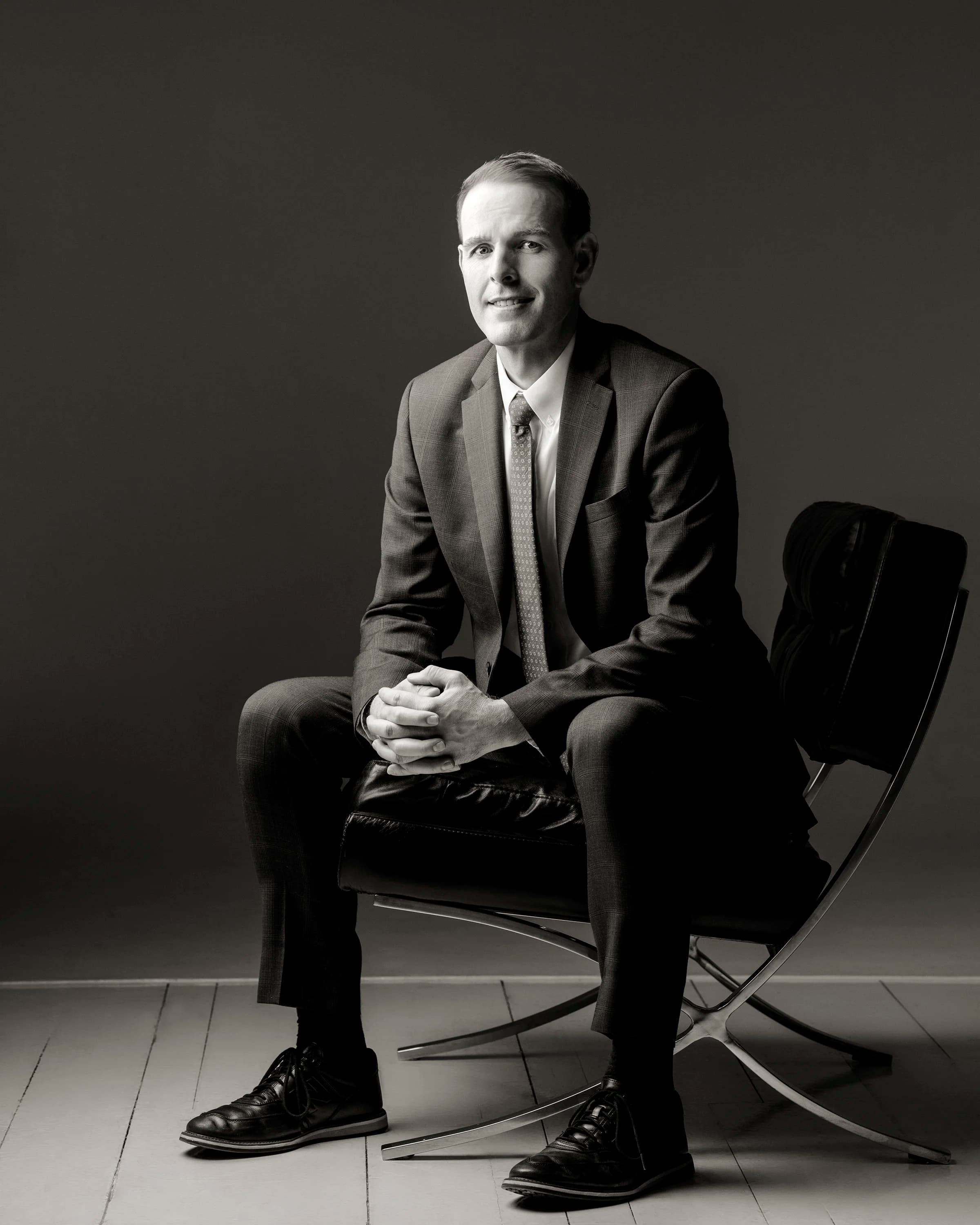 CJ Eagar, estate planning attorney, seated against a dark studio backdrop